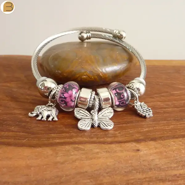 Bracelet acier avec breloques argentées éléphant chouette et papillon, perles noires et rose