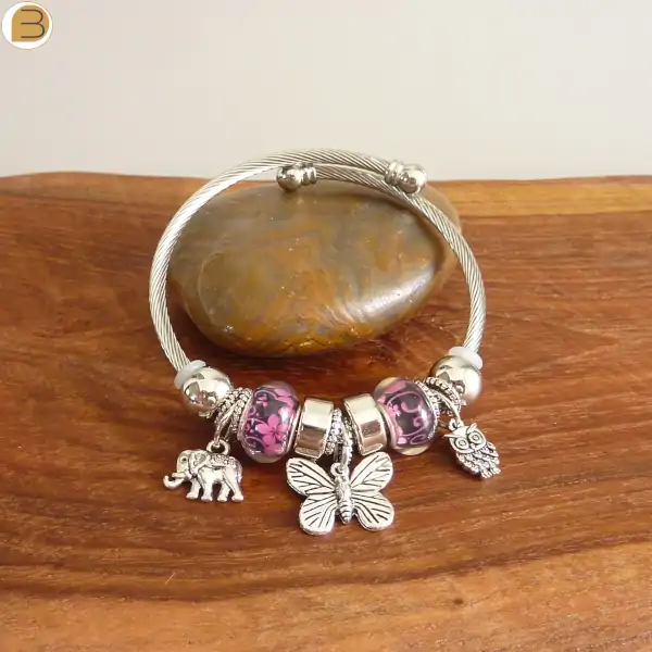 Bracelet acier avec breloques argentées éléphant chouette et papillon, perles noires et rose