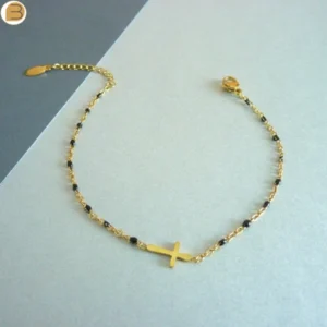 Bracelet en acier inoxydable doré pour femme avec ses fines perles noires et son pendentif croix chrétienne