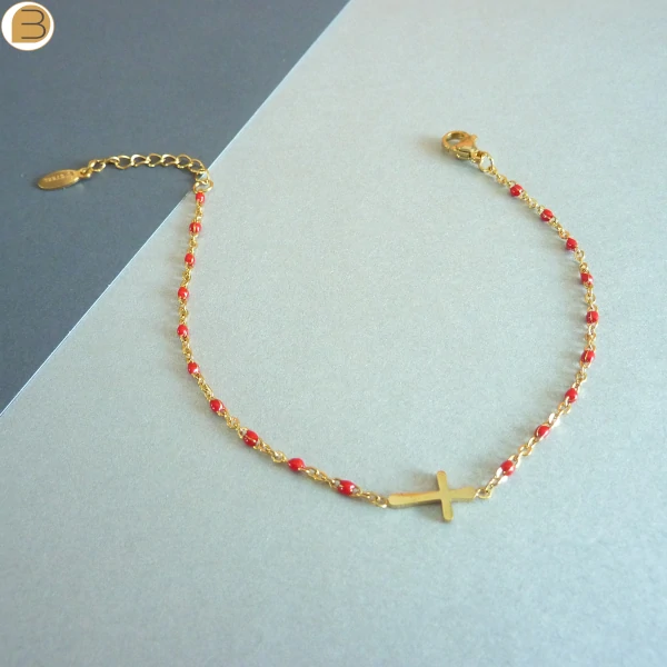 Bracelet en acier inoxydable doré pour femme avec ses fines perles rouge et son pendentif croix chrétienne