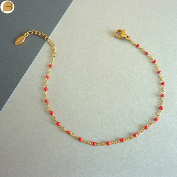 Bracelet en acier inoxydable doré pour femme avec ses fines perles rouge