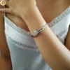 Bracelet en acier pour femme à ouverture charnière et clips de fermeture orné de zircons blancs