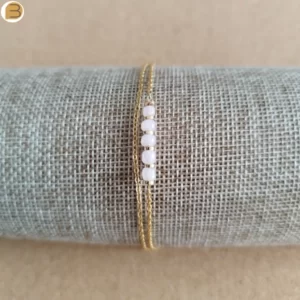 Bracelet pour femme en acier doré avec 2 chaines et fines perles en quartz rose. Création bijoutissimo.