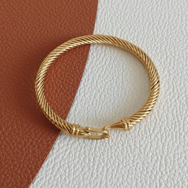 Bracelet torsadé en acier doré pour femme.