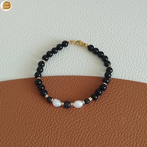Bracelet pour femme en acier doré, perles d'eau douce, pierre de lave, onyx noir, hématite. Création bijoutissimo.