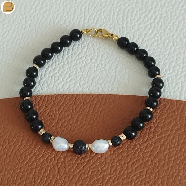Bracelet pour femme en acier doré, perles d'eau douce, pierre de lave, onyx noir, hématite. Création bijoutissimo.