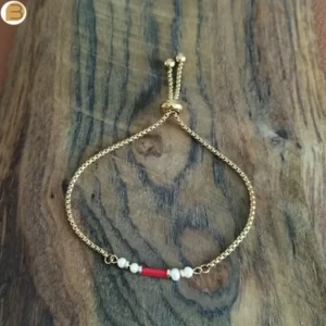 Bracelet réglable pour femme en acier doré orné de perles d'eau douce et de corail. Création bijoutissimo