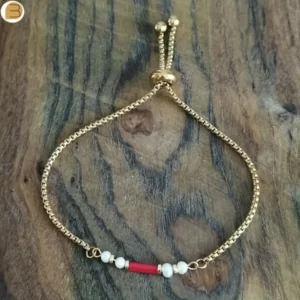 Bracelet réglable pour femme en acier doré orné de perles d'eau douce et de corail. Création bijoutissimo