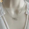 Collier pour femme en acier avec ses cœurs entrelacés - Création Bijoutissimo.