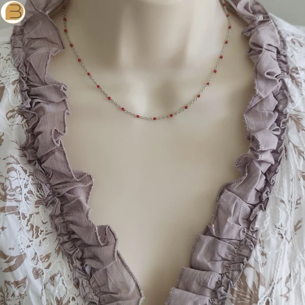 Collier ras de cou en acier inoxydable pour femme avec ses fines perles rouges.