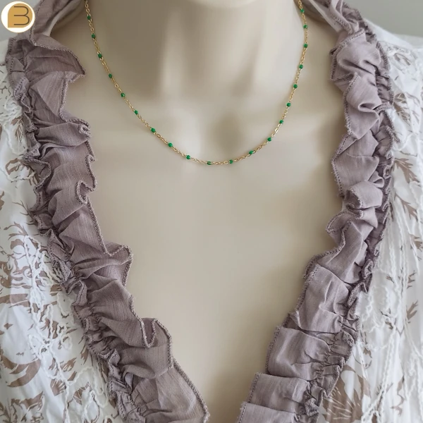 Collier ras de cou en acier inoxydable doré pour femme avec ses fines perles vert-émeraude.