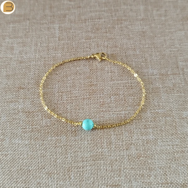 Bracelet acier doré avec sa perle ronde en turquoise et ses perles acier