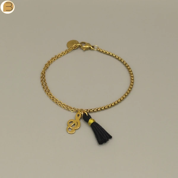 Bracelet fait main en France pour femme en acier inoxydable doré, chaîne asymétrique, pendentifs pompon et note de musique.
