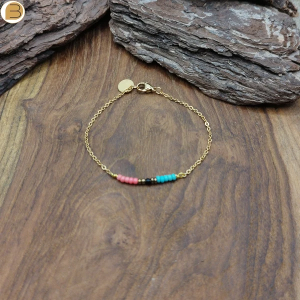 Bracelet en acier doré pour femme, orné de petites perles multicolores bleues, rose. Une Création Bijoutissimo.