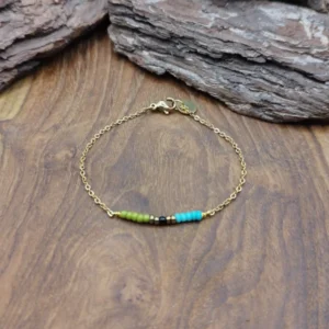 Bracelet en acier doré pour femme, orné de petites perles multicolores bleues, vertes. Une Création Bijoutissimo.