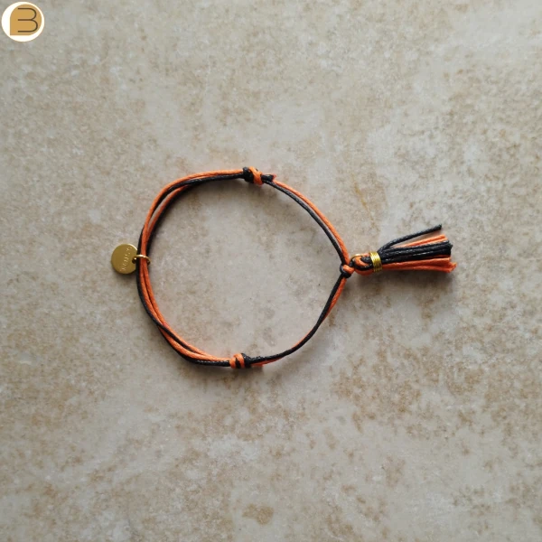 Bracelet réglable double cordon et pompon en coton orange et noir fait main en France