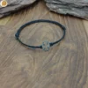 Bracelet minimaliste cordon noir réglable avec trèfle à quatre feuille en acier inoxydable. Fait main en France.