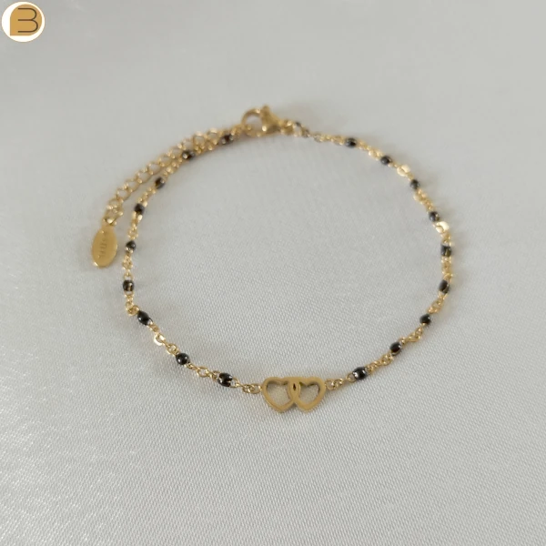 Bracelet en acier inoxydable doré pour femme avec ses fines perles noires et son pendentif cœur