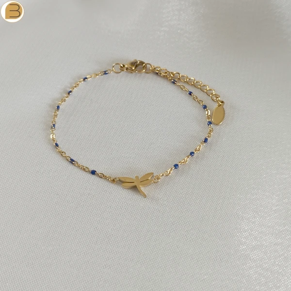 Bracelet en acier inoxydable doré pour femme avec ses fines perles bleues et son pendentif libellule.
