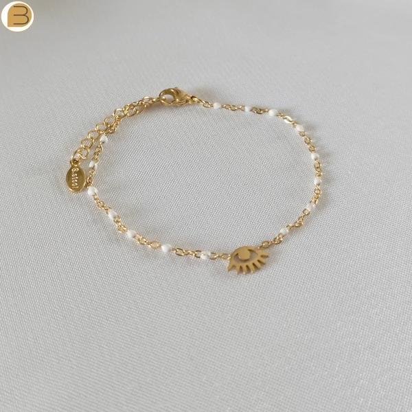 Bracelet en acier inoxydable doré pour femme avec ses fines perles blanches et son pendentif mauvais œil.